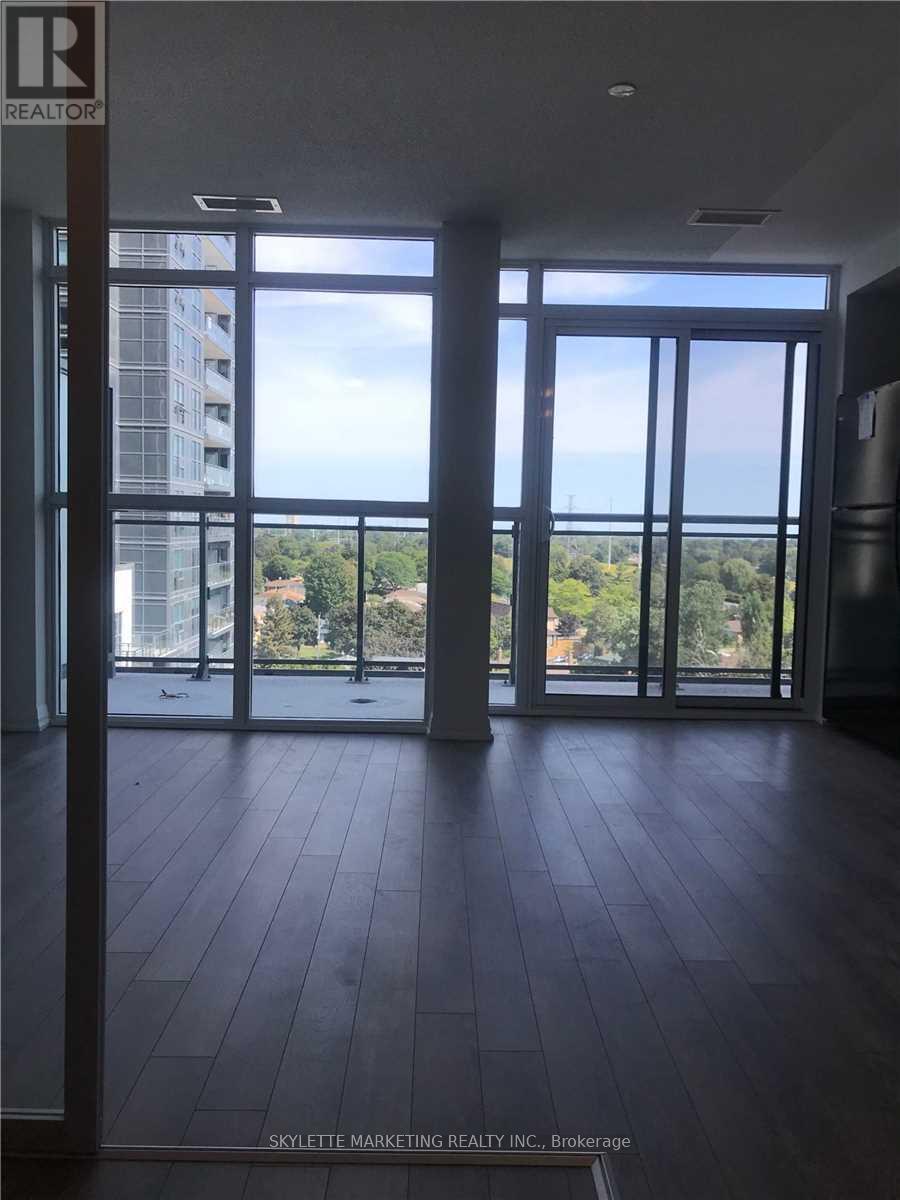 A room with a view of a cityscape through large windows.