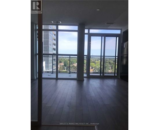 A room with a view of a cityscape through large windows.