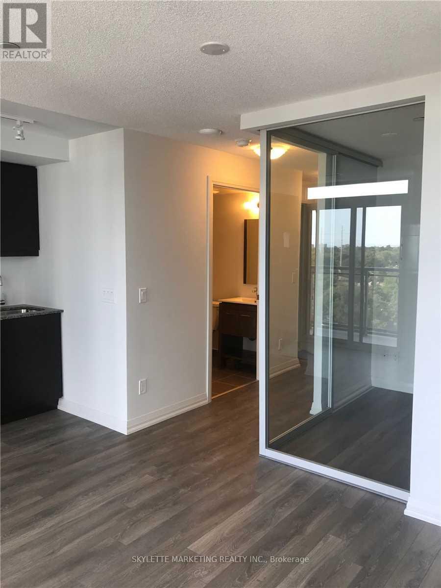 A modern living room with a television and a glass door leading to a balcony.