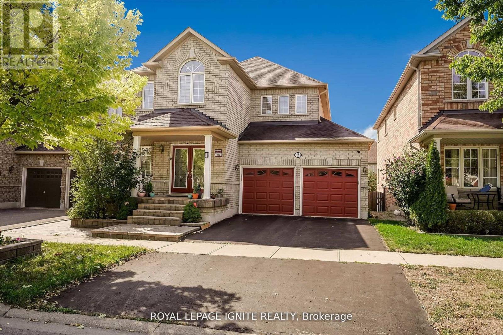 A large house with a red garage door is for sale.