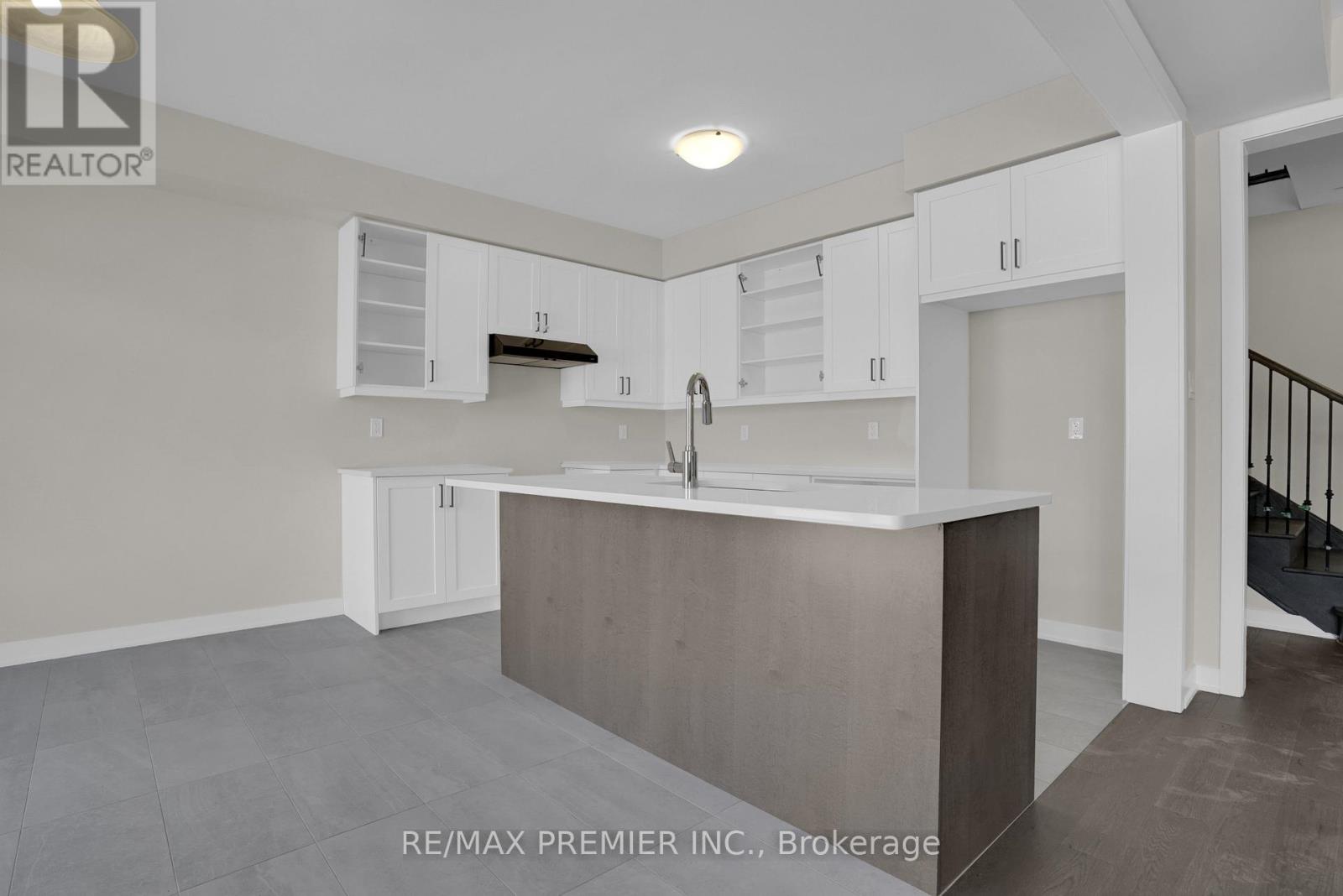 A kitchen with white cabinets and a wooden island.