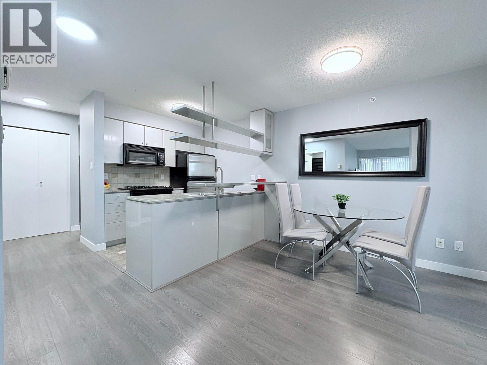 A modern kitchen with a dining table and chairs.