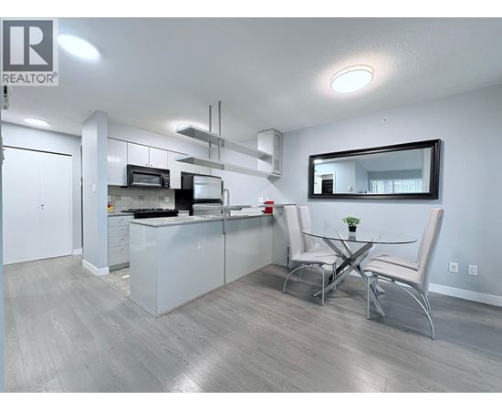 A modern kitchen with a dining table and chairs.