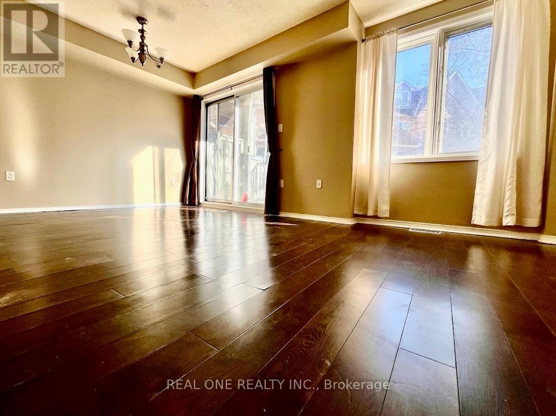 A room with wooden flooring and a window with curtains.