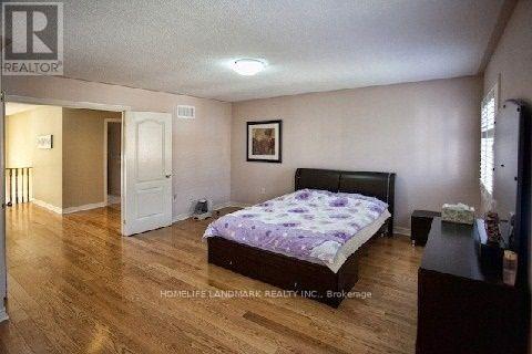 A bedroom with a bed, dresser, and a painting on the wall.