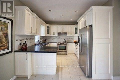 A kitchen with white cabinets and a black counter top.