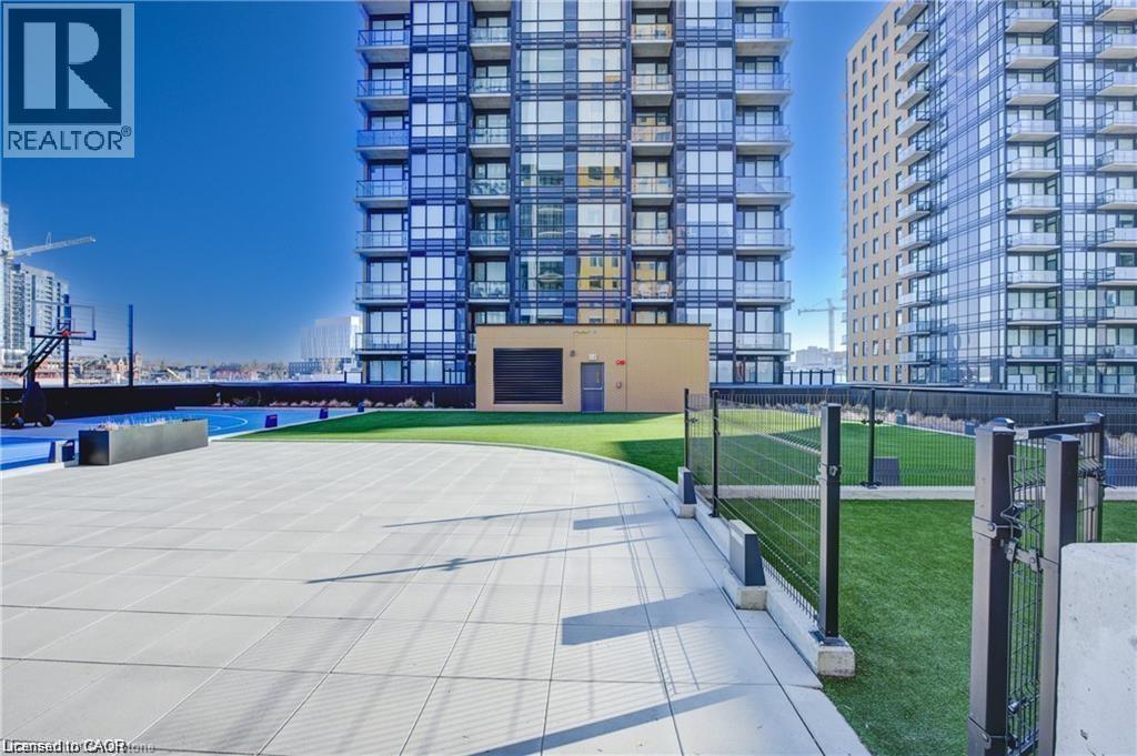 A modern building with a glass facade and a large open space in front.