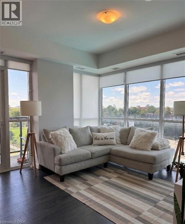A living room with a grey couch and a large window.