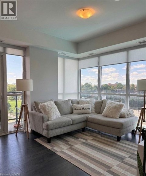 A living room with a grey couch and a large window.