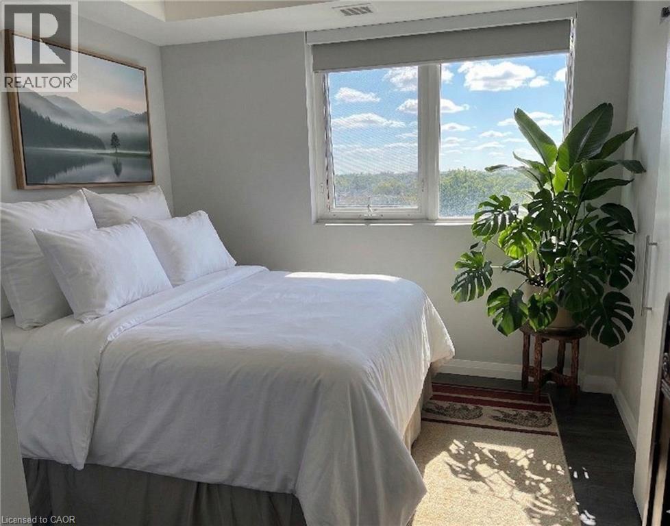 A bedroom with a large bed and a window overlooking a landscape.