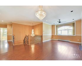 A large empty room with wooden floors and a chandelier.