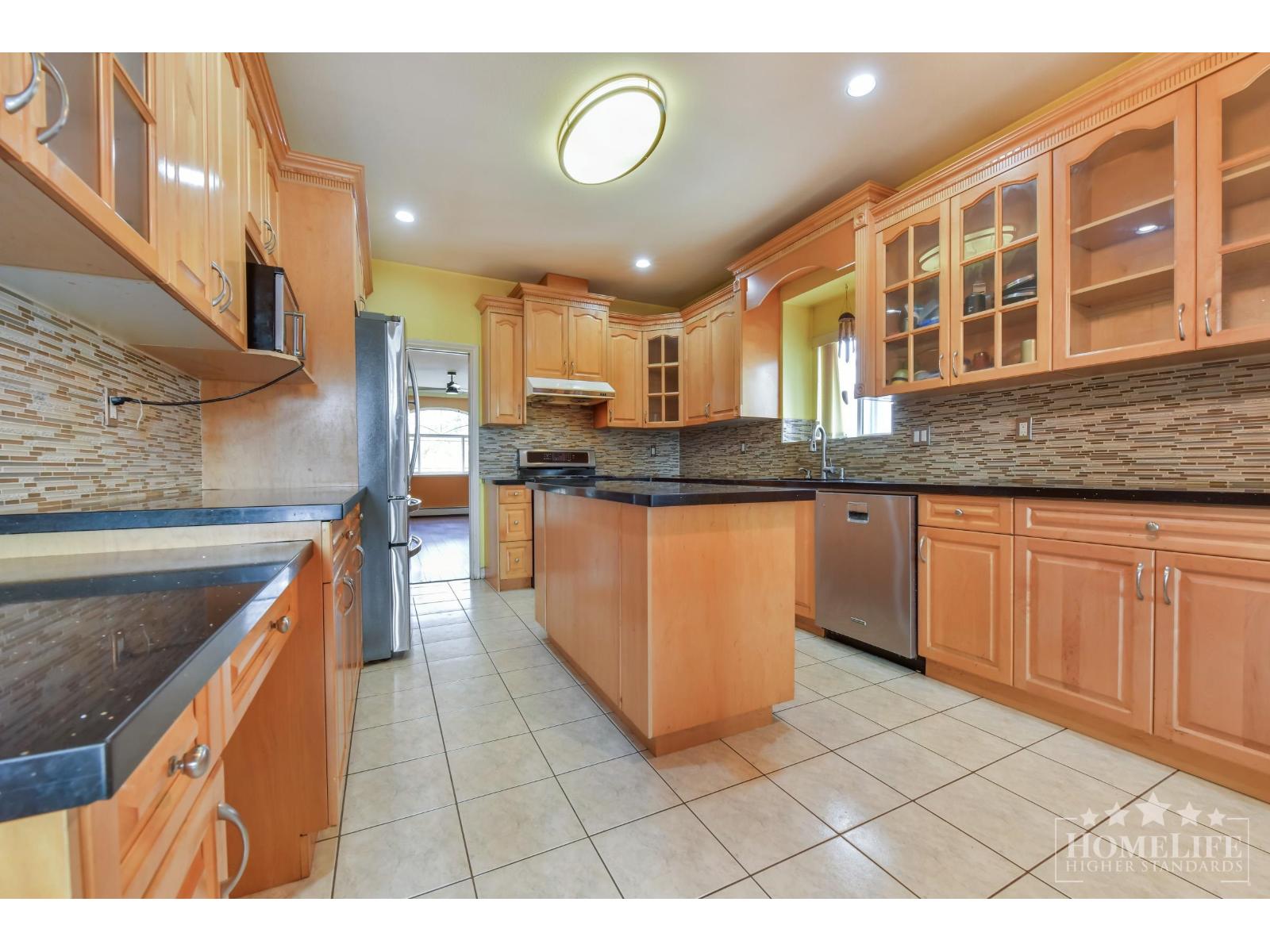A kitchen with wooden cabinets and a black countertop.