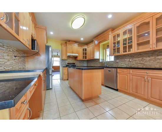 A kitchen with wooden cabinets and a black countertop.