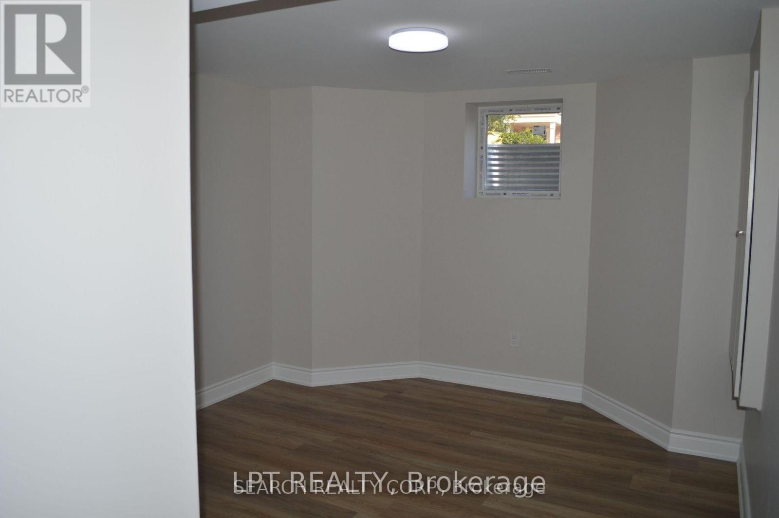 A room with a window and wooden flooring.