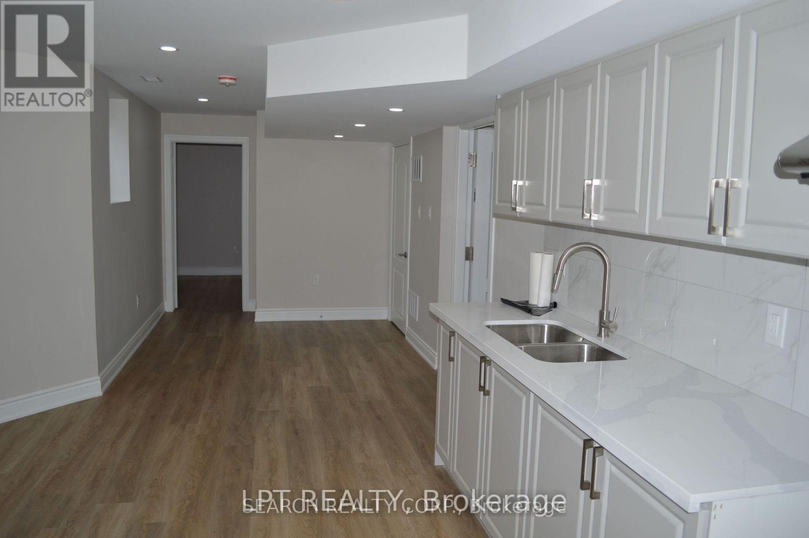 A kitchen with white cabinets and a sink.