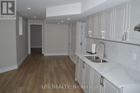 A kitchen with white cabinets and a sink.