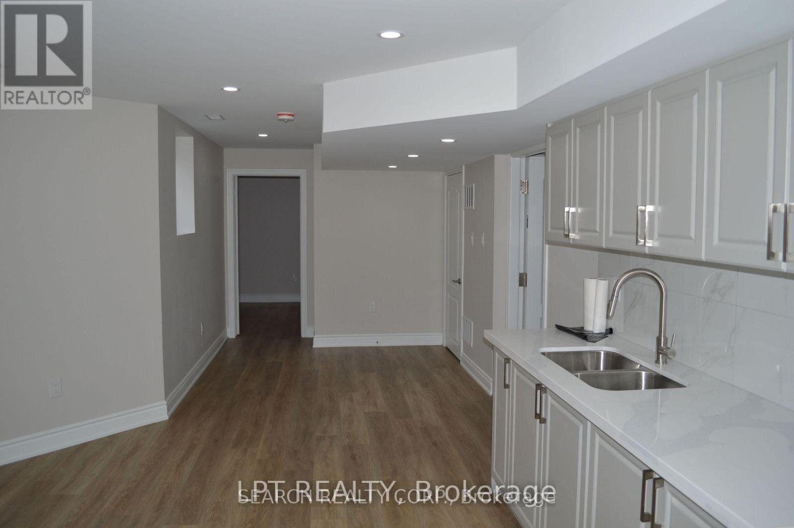 A kitchen with white cabinets and a sink.