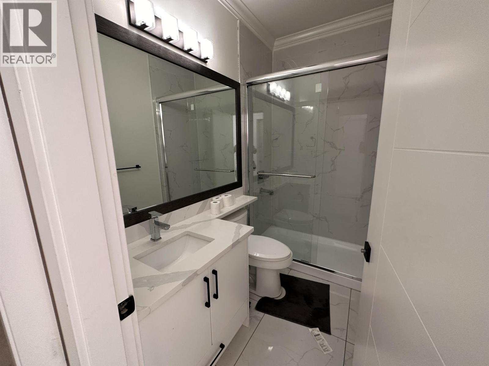 A bathroom with a sink, toilet, and shower.