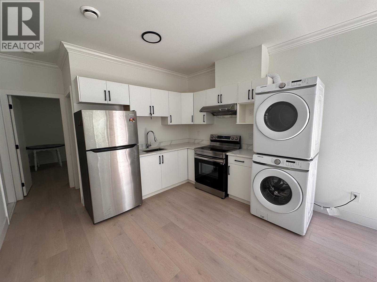 A kitchen with a stainless steel refrigerator, oven, and dishwasher.