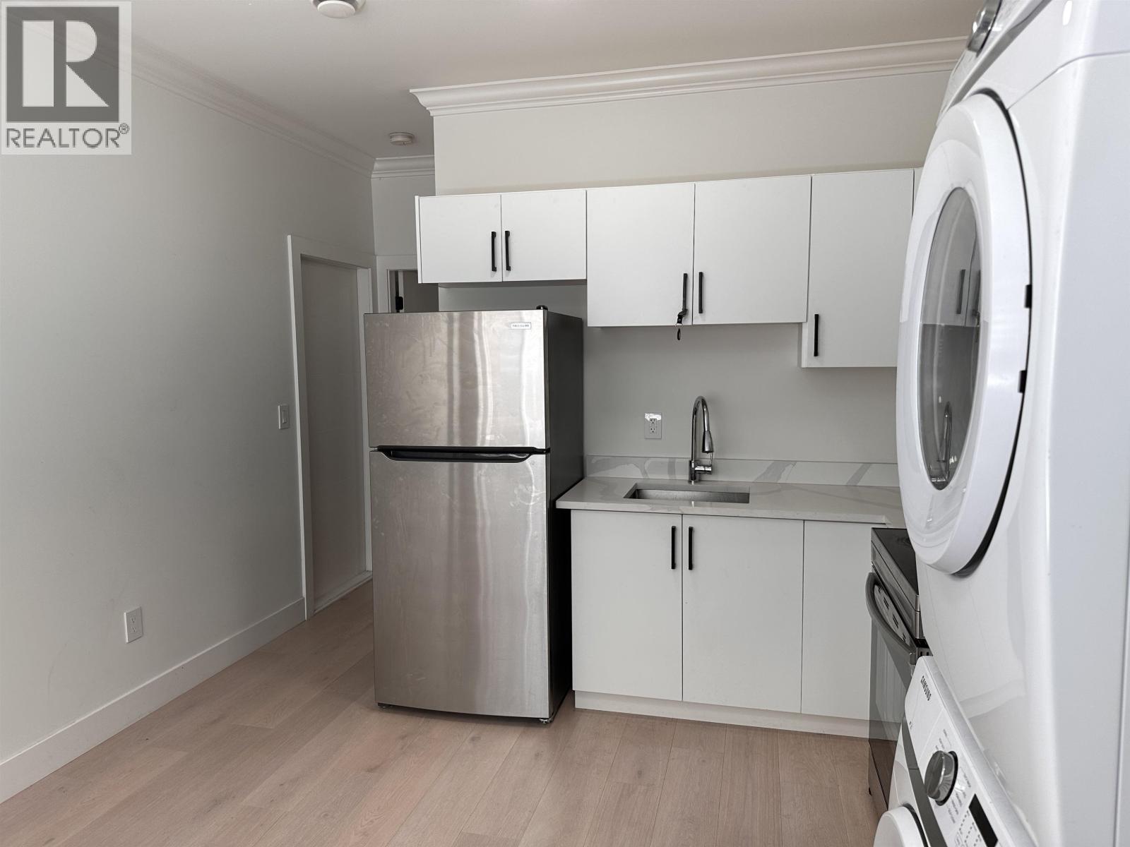A kitchen with white cabinets and stainless steel appliances.