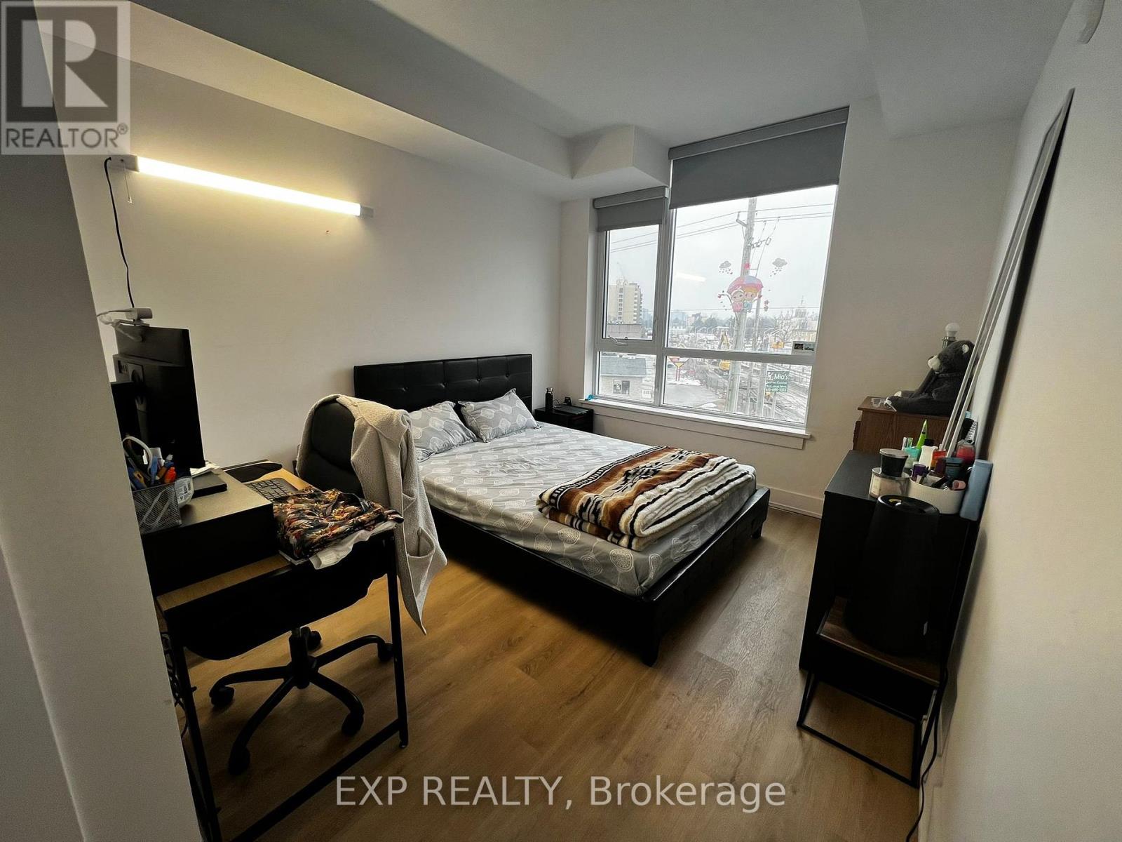 A bedroom with a bed, desk, and chair.