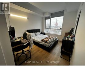 A bedroom with a bed, desk, and chair.