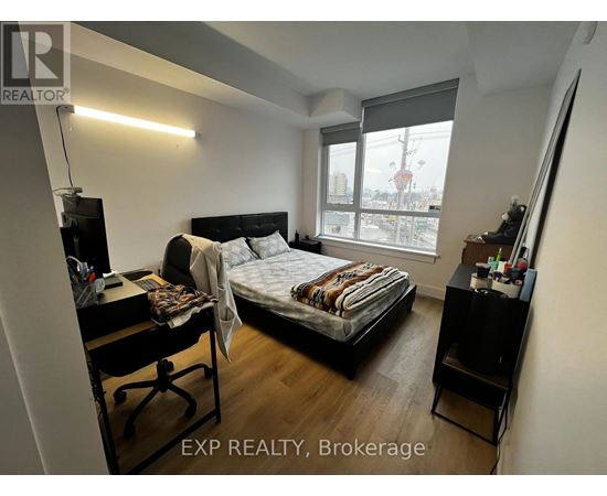 A bedroom with a bed, desk, and chair.