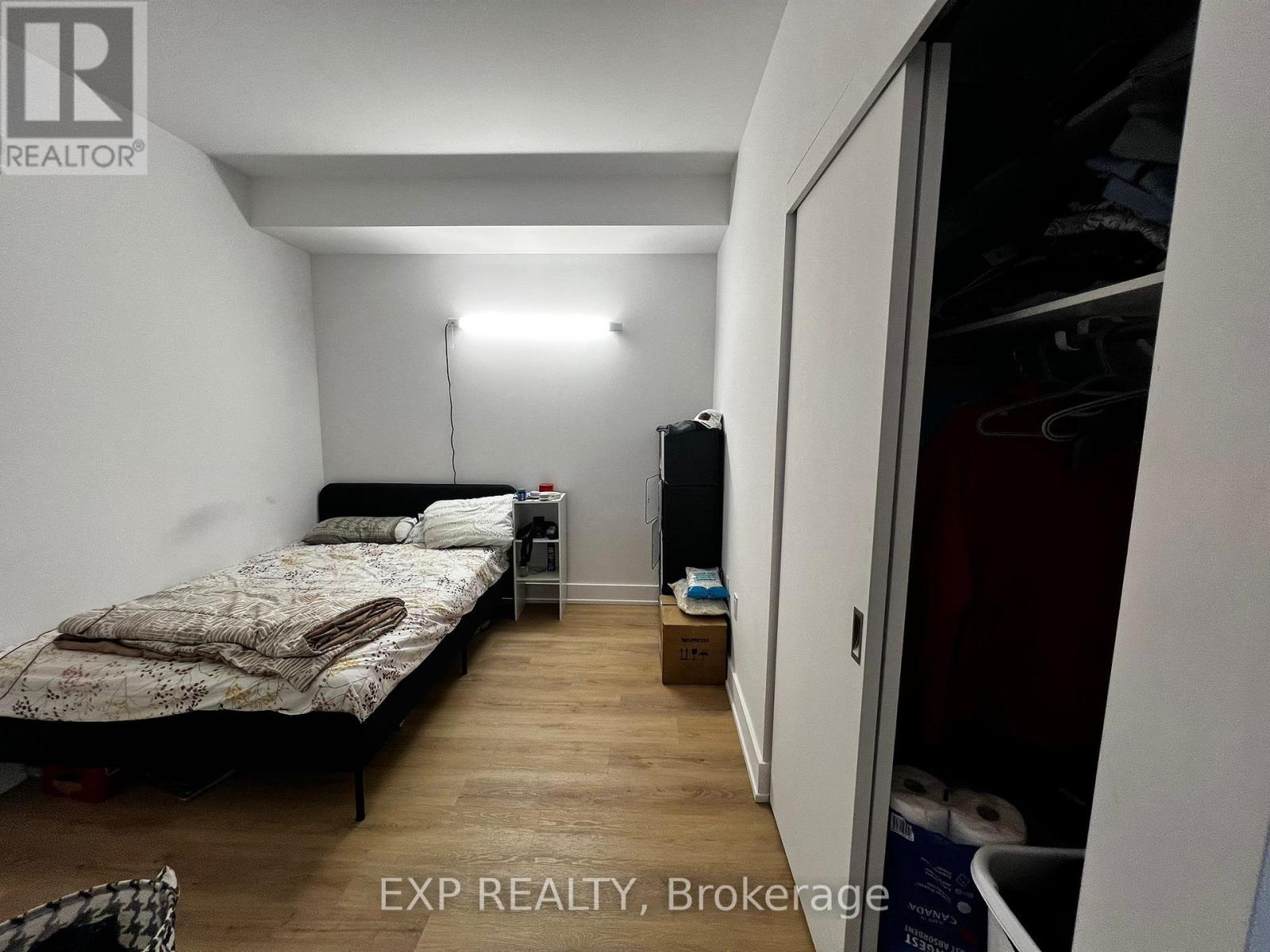 A bedroom with a bed, nightstand, and a lamp.