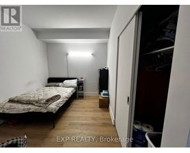A bedroom with a bed, nightstand, and a lamp.