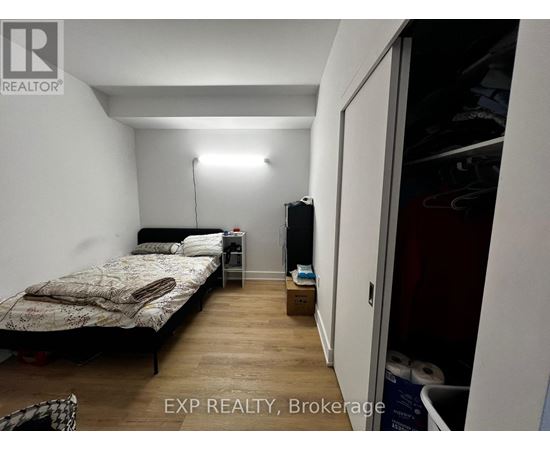 A bedroom with a bed, nightstand, and a lamp.