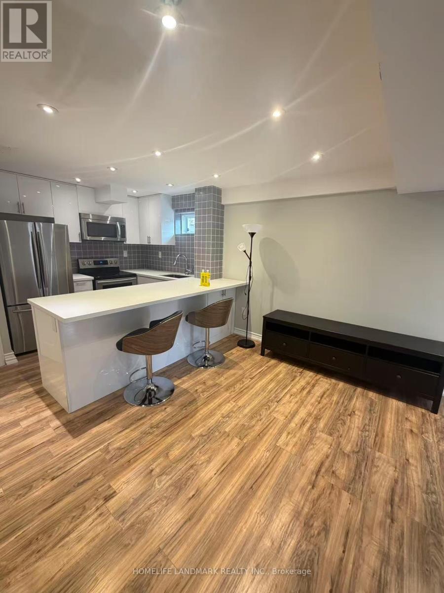 A modern kitchen with wooden flooring and a white island.
