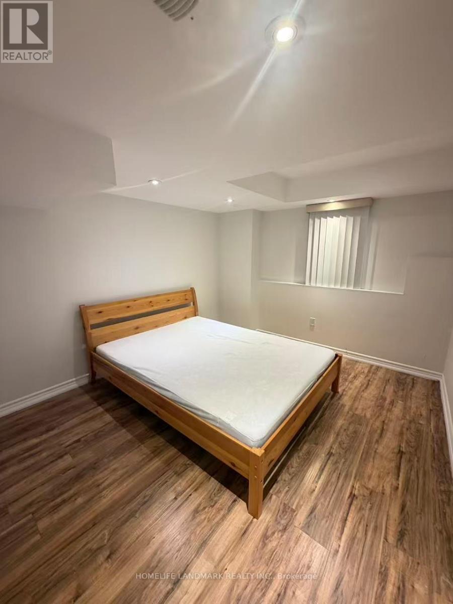 A bedroom with a bed and wooden flooring.