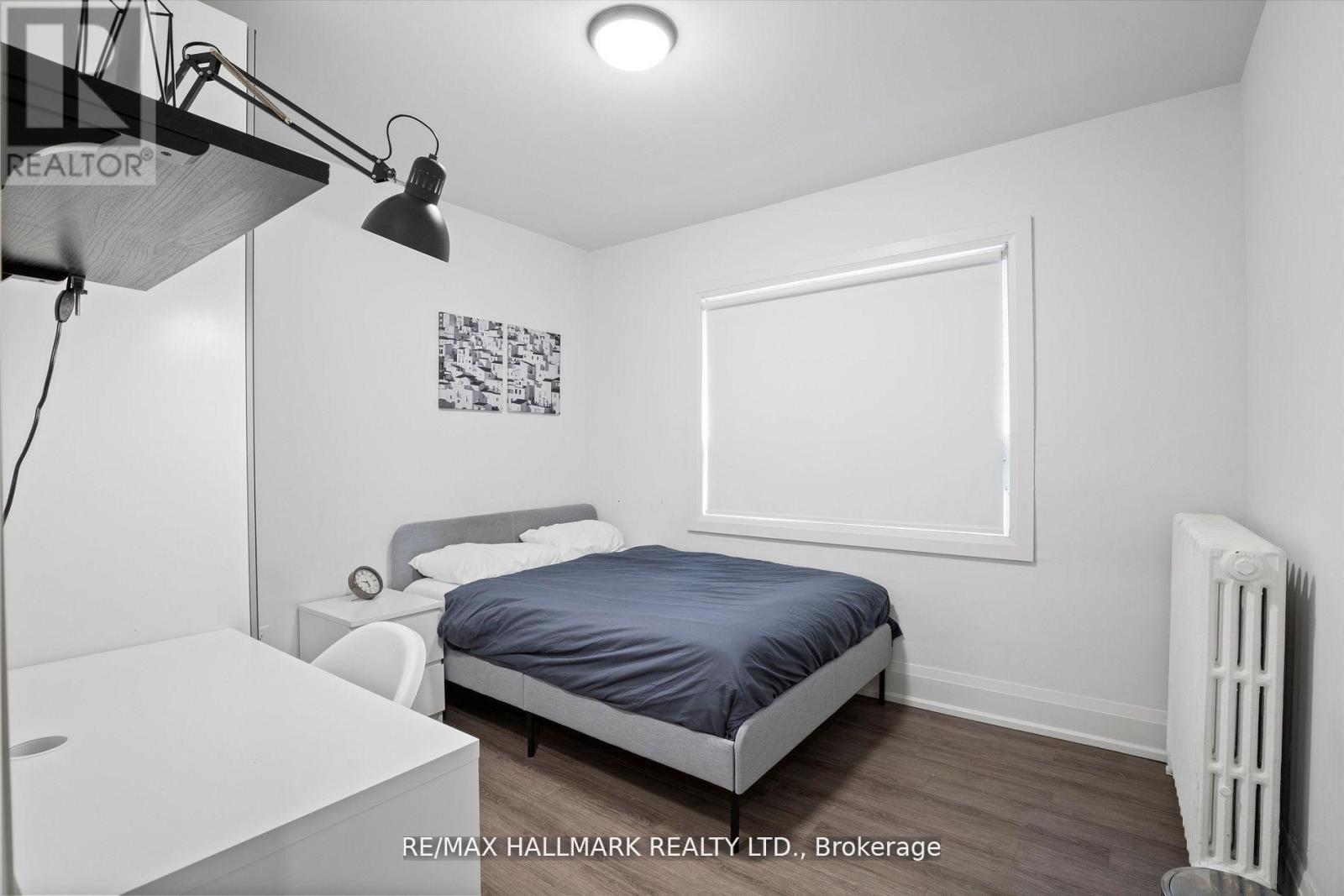 A bedroom with a bed, nightstand, and lamp.