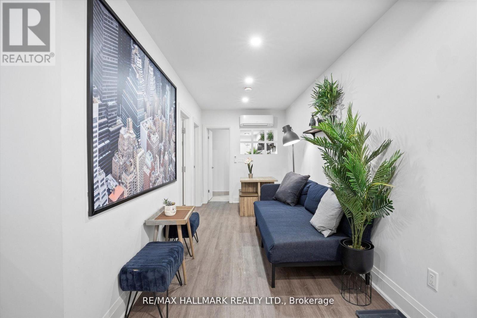 A living room with a couch, a table, and a potted plant.