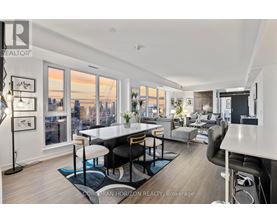 A well-lit, modern living room with a view of the city skyline.