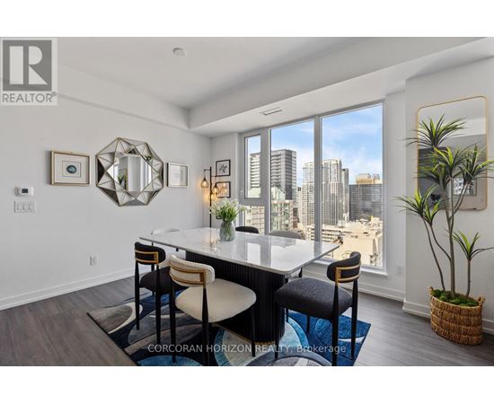A dining room with a table and chairs and a view of the city.