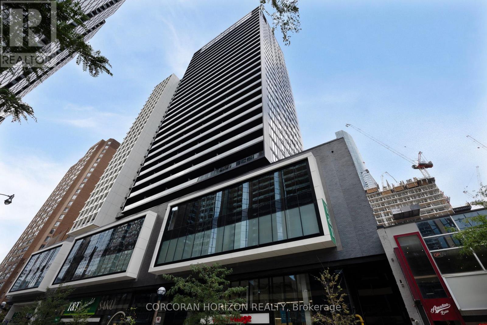 A tall building with a sign that says "CORCORAN HORIZON REALTY Brokerage" in front of it.