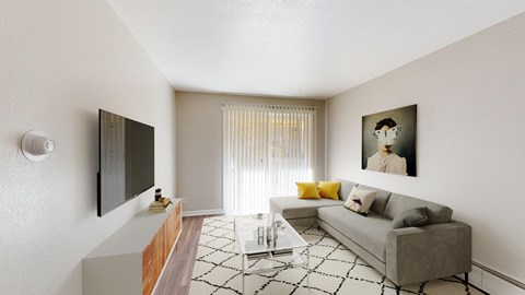 A living room with a grey couch, a coffee table, a television, and a painting on the wall.