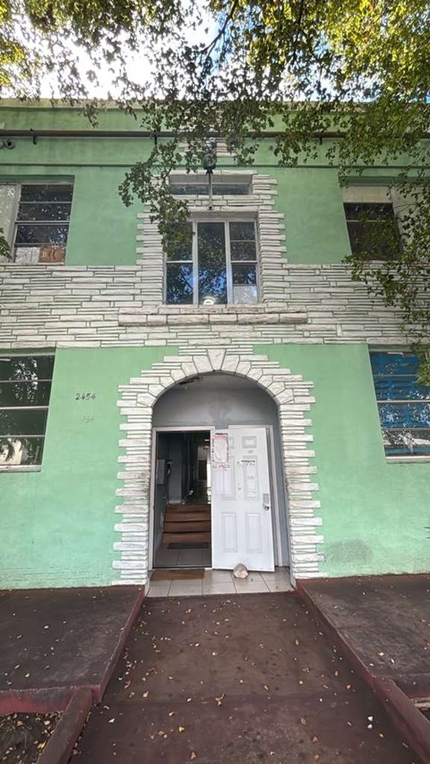 A green building with a white door and a window.