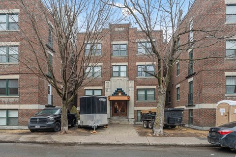A brick building with a black truck parked in front.