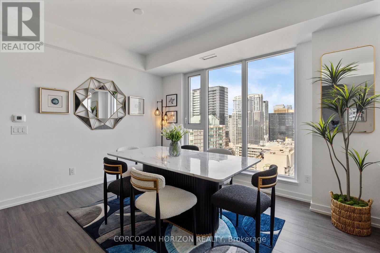 A dining room with a table and chairs and a view of the city.