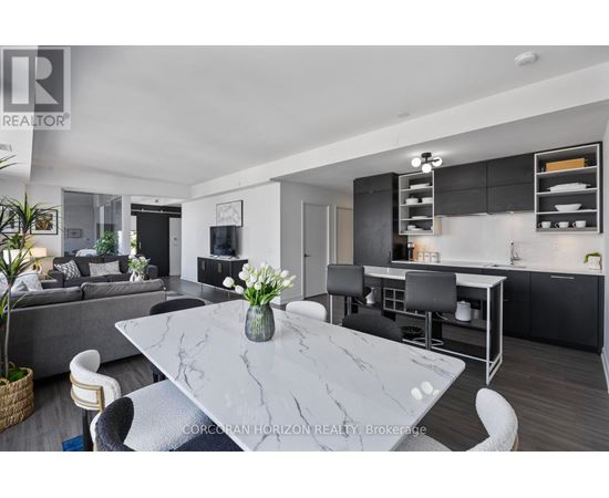 A modern kitchen with a marble table and black chairs.