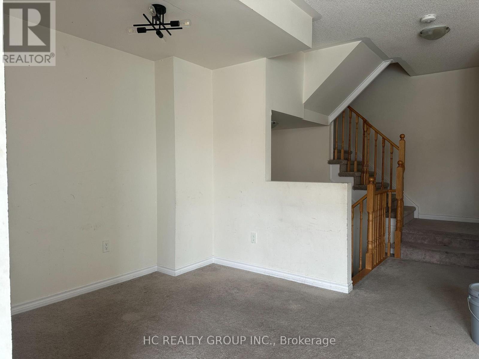A room with a staircase and a ceiling fan.