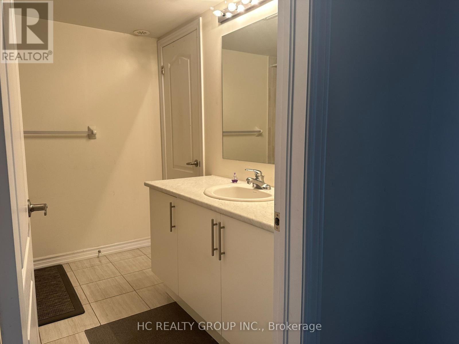 A bathroom with a sink, mirror, and cabinet.