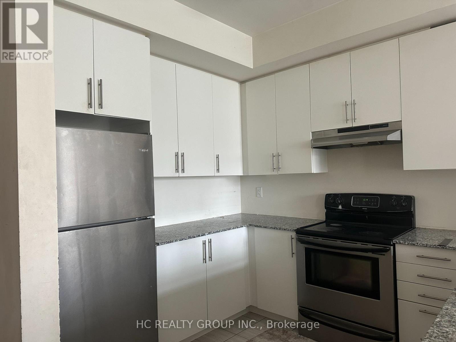 A kitchen with white cabinets and a black stove top oven.