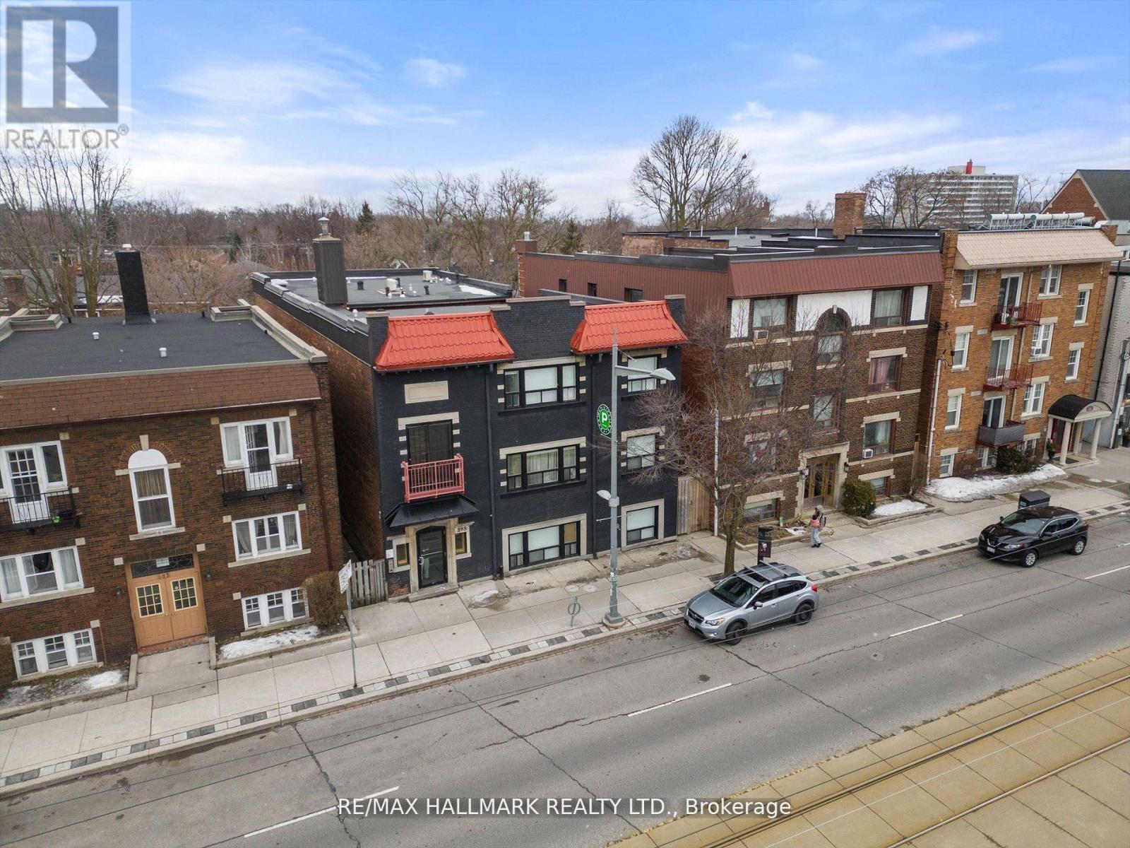 A street view of a residential area with cars parked on the side of the road.