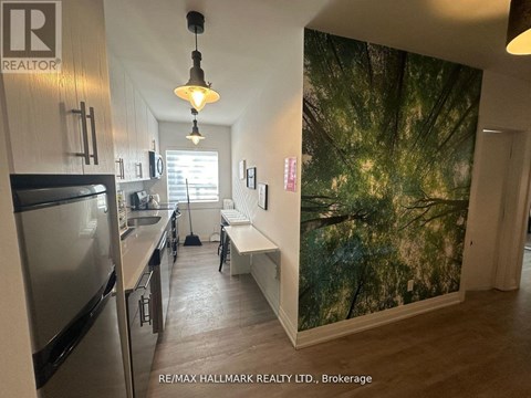 A kitchen with a refrigerator and a wall mural.