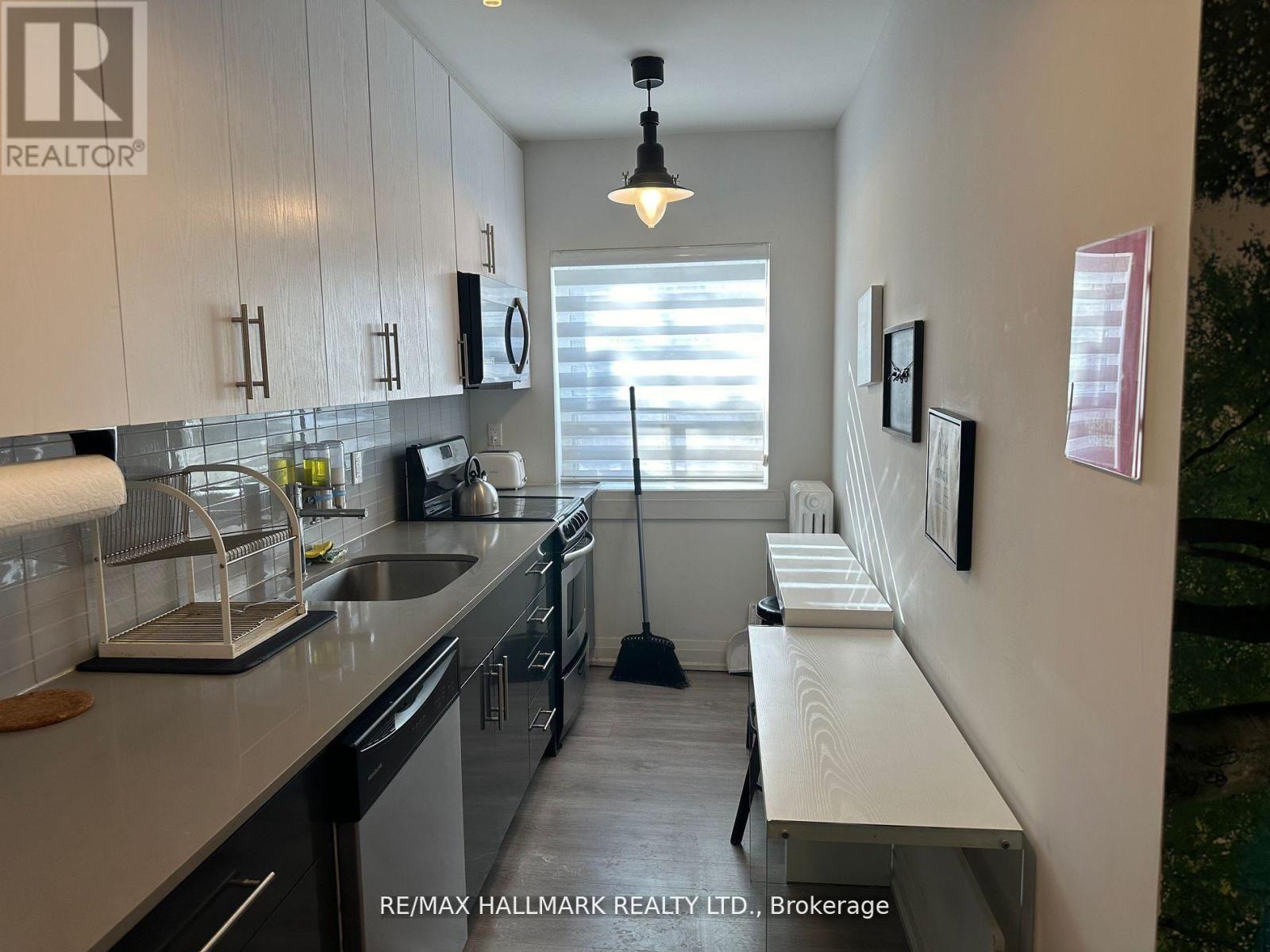 A kitchen with white cabinets and a black vacuum cleaner.