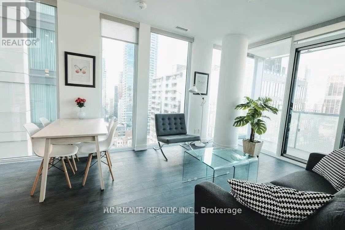 A living room with a couch, a dining table and a plant.