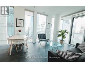 A living room with a couch, a dining table and a plant.